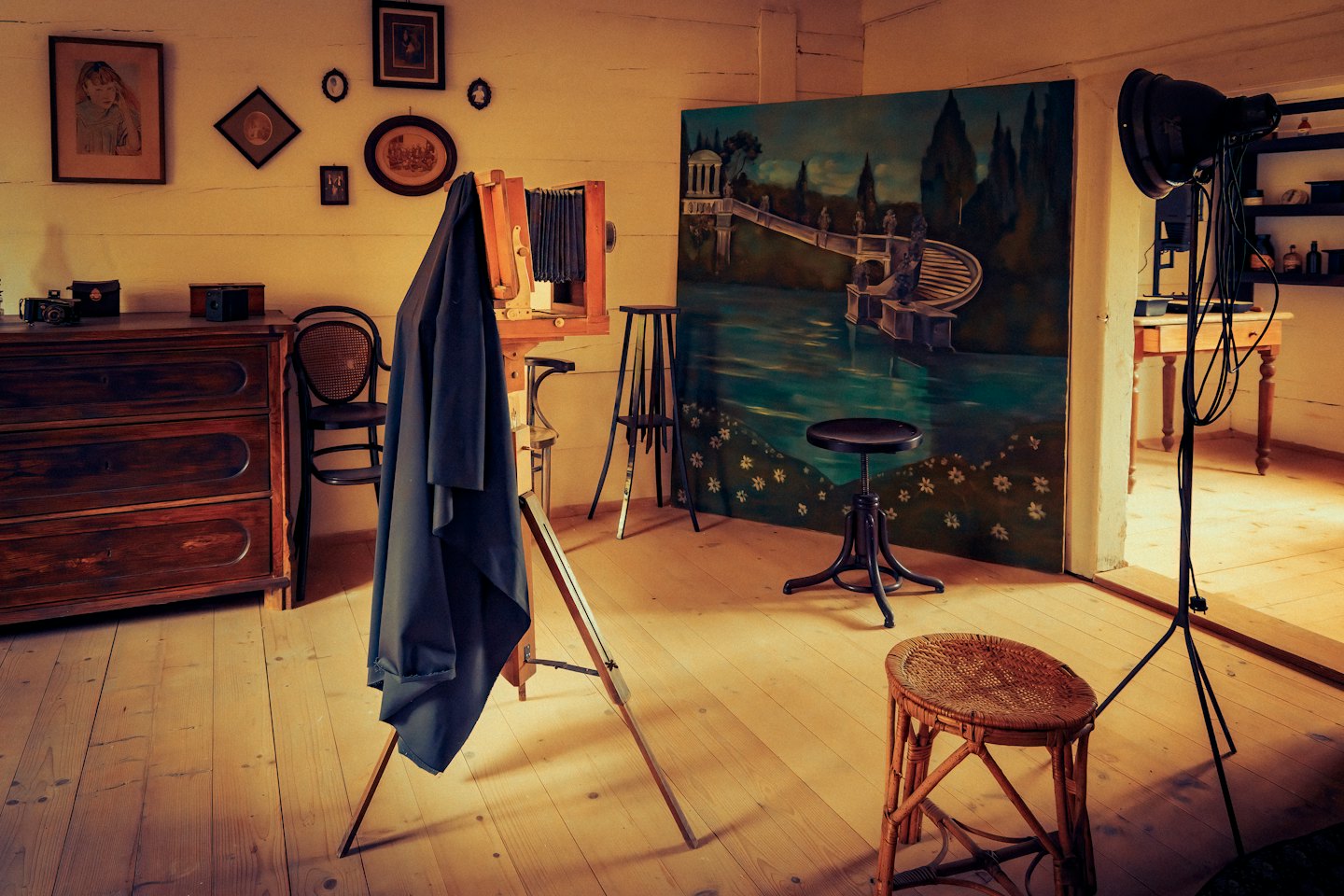 Vintage wooden camera on a tripod inside a photography studio.